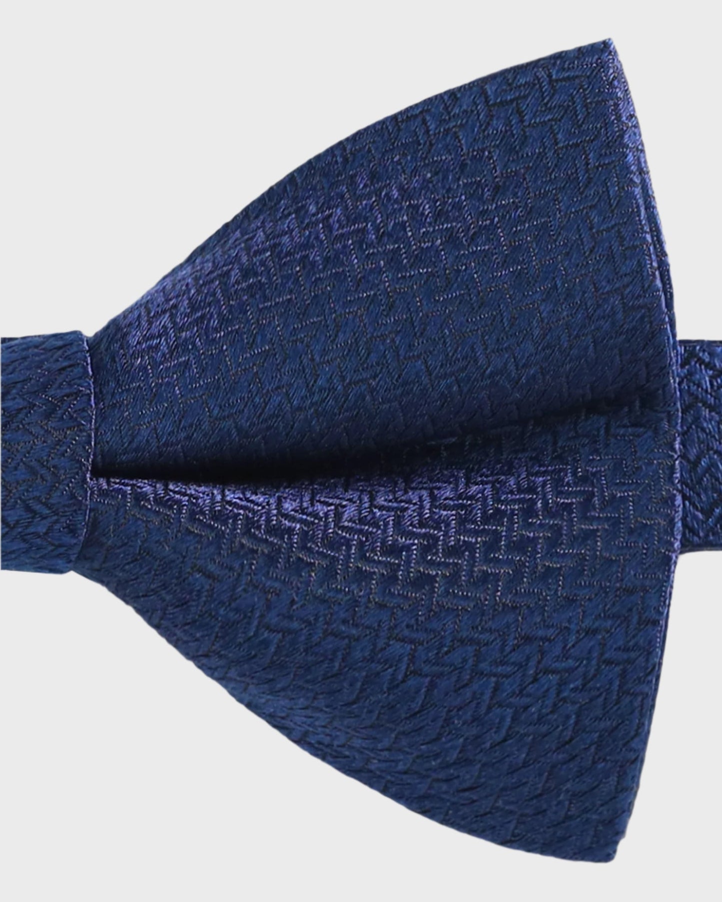 Blue textured bow tie on a light gray background