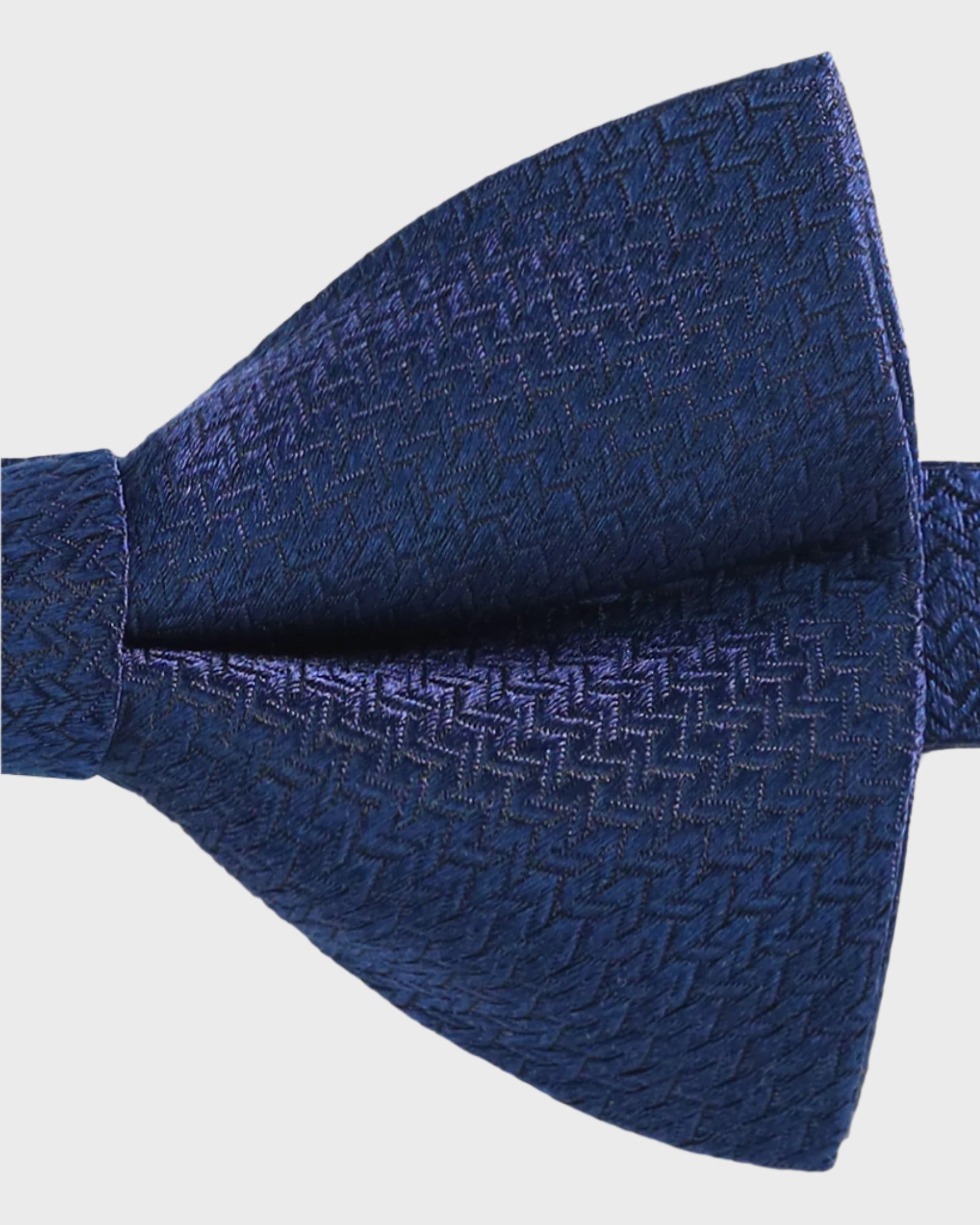 Blue textured bow tie on a light gray background