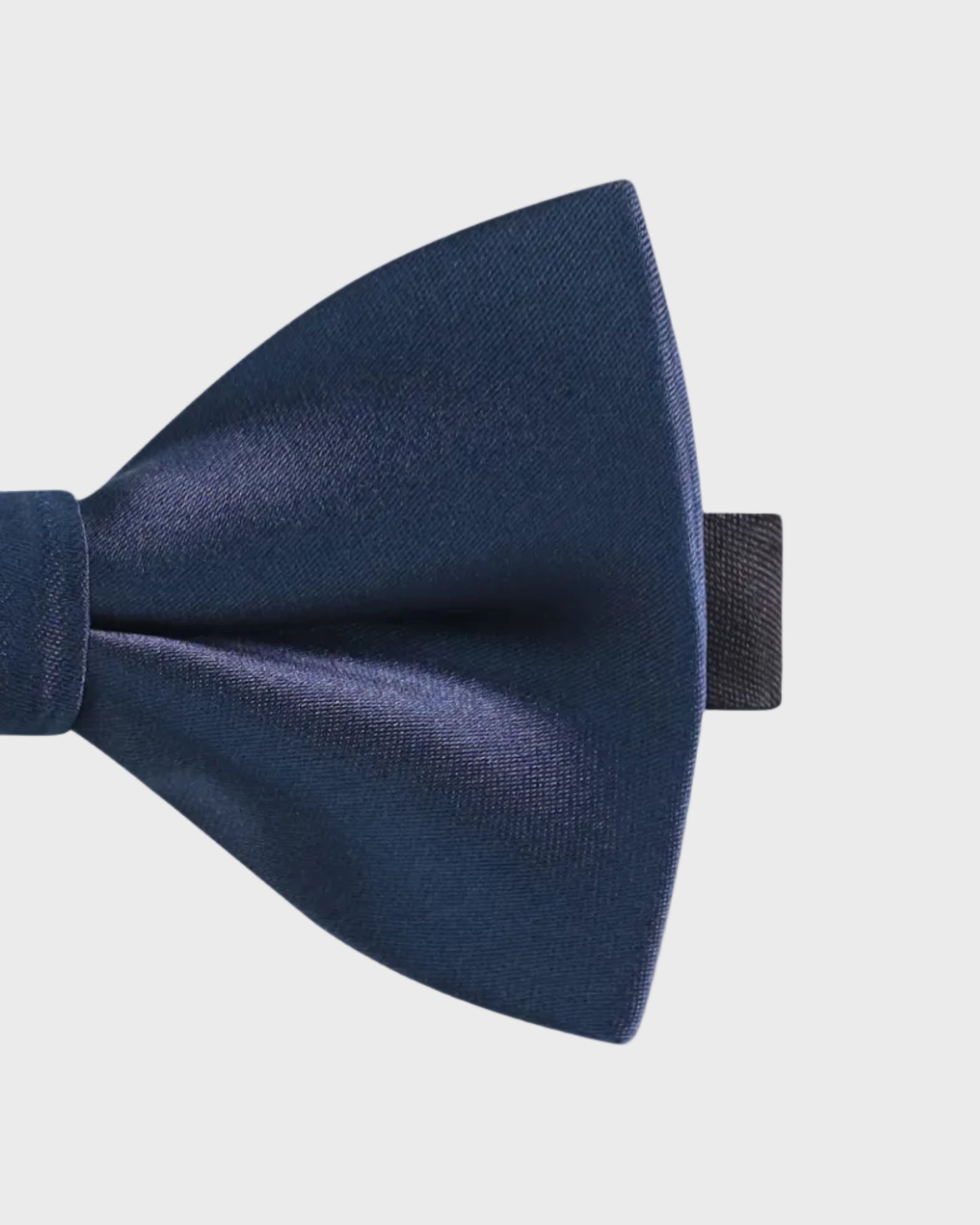 Navy blue bow tie on a light gray background