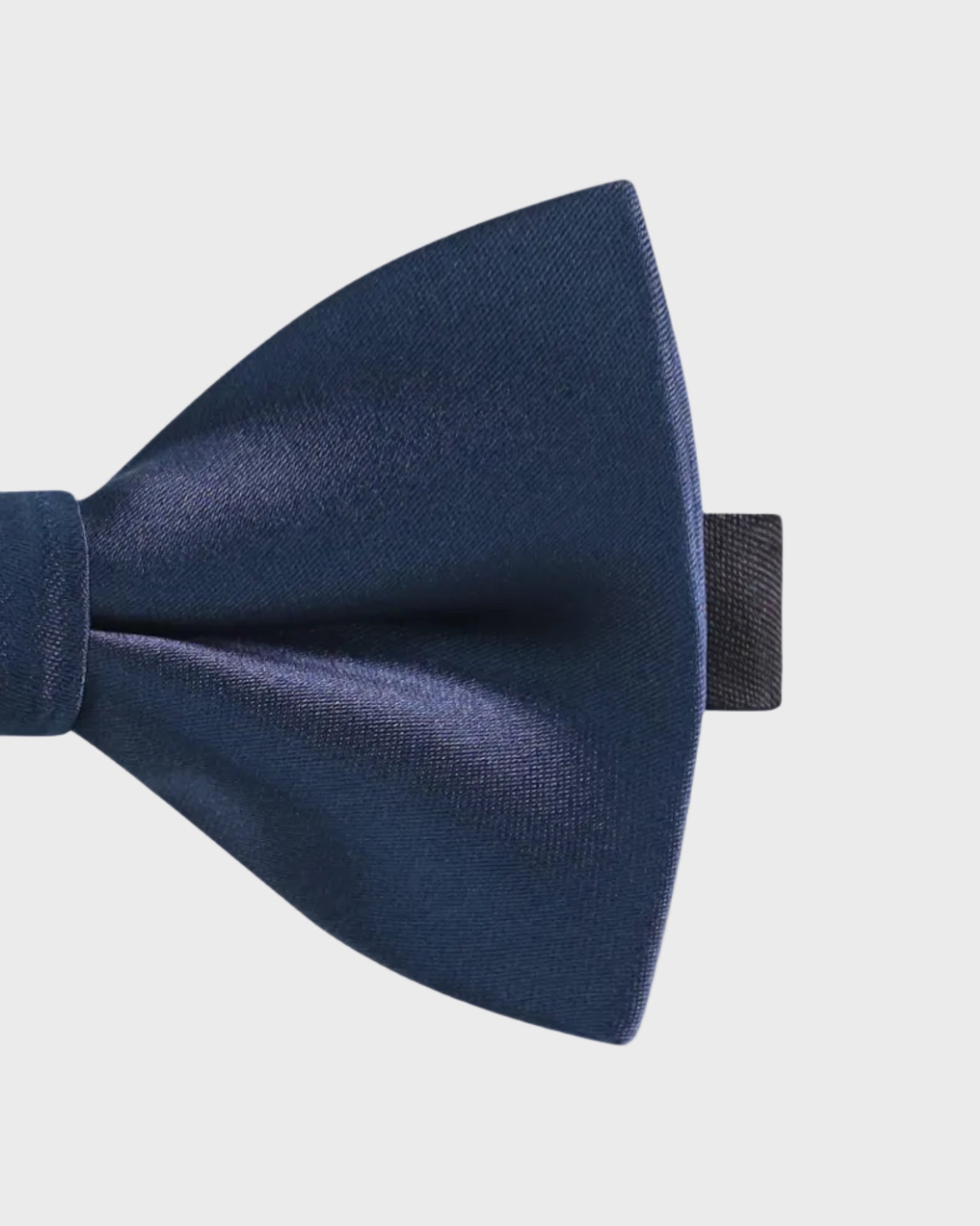 Navy blue bow tie on a light gray background