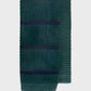Green knitted tie with dark blue stripes on a light gray background