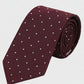 Maroon tie with white polka dots on a light gray background