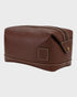 brown leather toiletry bag with a strap on a white background