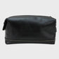 Black leather toiletry bag on a light gray background