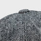 Close-up of a textured black and white fabric with a button on a light gray background