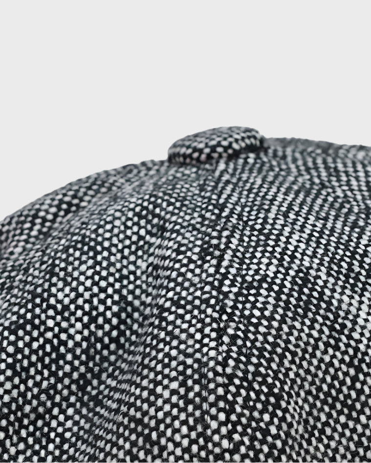 Close-up of a textured black and white fabric with a button on a light gray background