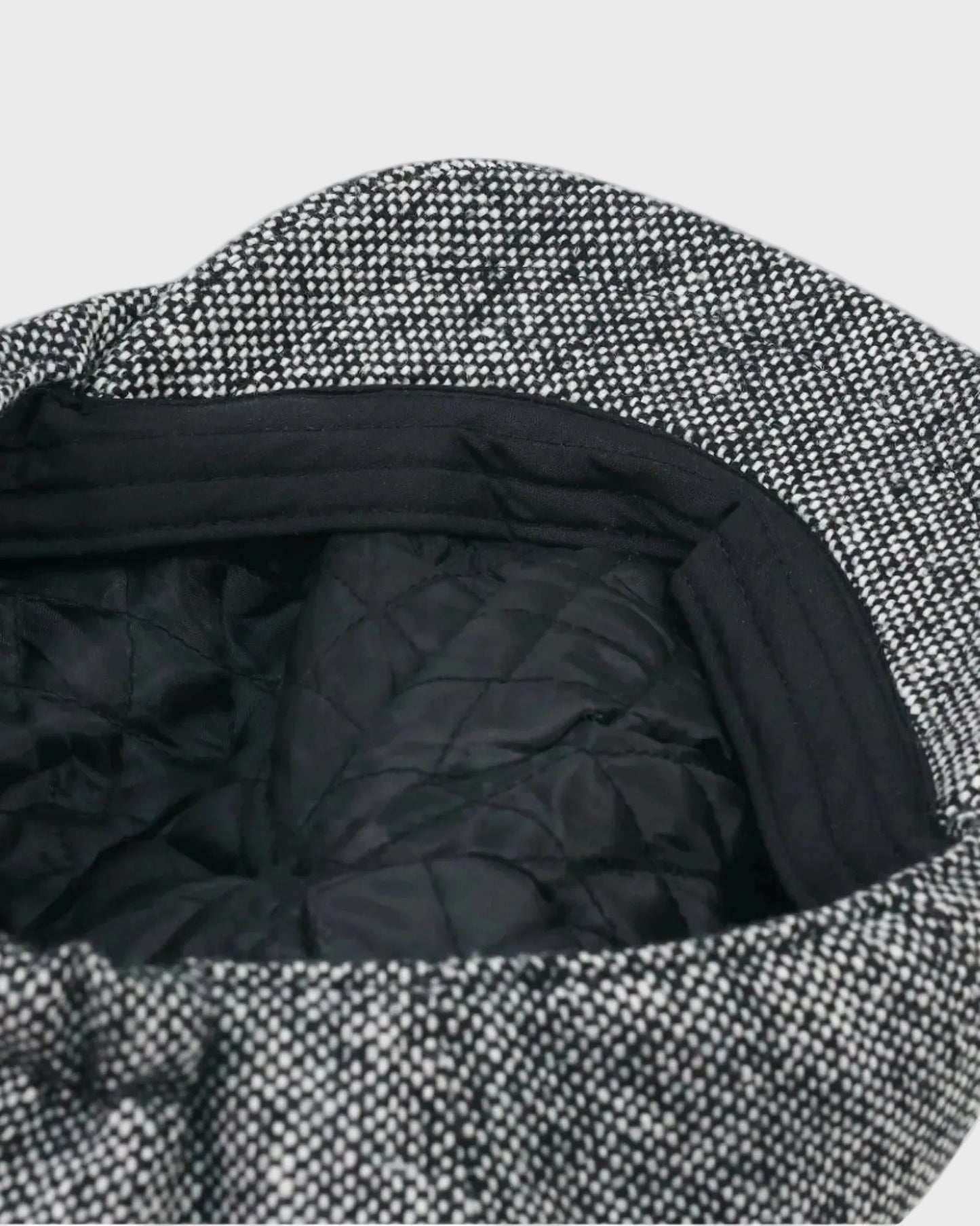 Close-up of a textured fabric with black quilted lining on a white background