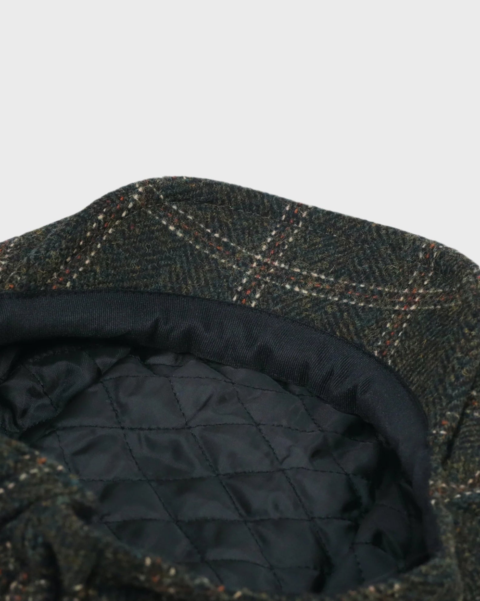 Harris Tweed cap with quilted lining on a light gray background