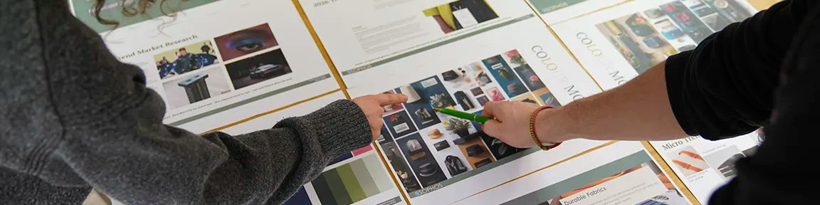 Two people looking at design sketches on a table