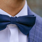 Navy blue bow tie worn by a person with a blurred background