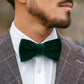 Man wearing a green velvet bow tie with a brown suit and white shirt.
