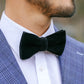 Man wearing a green bow tie with a blue checkered suit jacket.